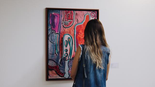 Paula Falcão observa obra no Museu de Arte de Goiânia