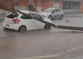 Poste cai em cima de carro que passava por rua durante chuva, em Goiânia
