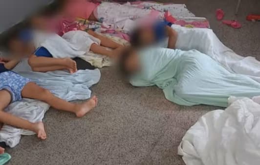 crianças dormindo no chão em escola
